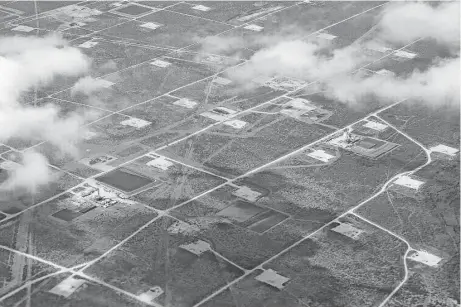  ?? Michael Ciaglo photos / Houston Chronicle ?? An aerial view of the Permian Basin outside of Midland shows the football field-size rectangles of land cleared by oil drillers.