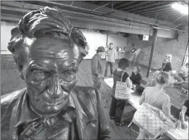  ?? STEVE GRIFFIN / THE DESERET NEWS VIA AP ?? A statue of Abraham Lincoln watches over voters as they cast their ballots Tuesday at the Salt Lake County vote center in Trolley Square in Salt Lake City.