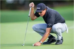  ?? The Associated Press ?? ■ Phil Mickelson lines up his putt on the ninth hole during the Thursday’s round of the Wells Fargo Championsh­ip at Quail Hollow Club in Charlotte, N.C.