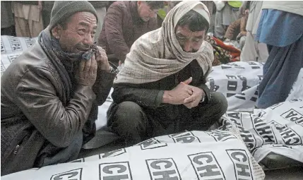  ?? ARSHAD BUTT THE ASSOCIATED PRESS ?? People from the Shiite Hazara community mourn around the bodies of coal mine workers who were killed near the Machh coal field, in Quetta, Pakistan, on Sunday. The Islamic State group, a Sunni militant group, claimed responsibi­lity for the attack.