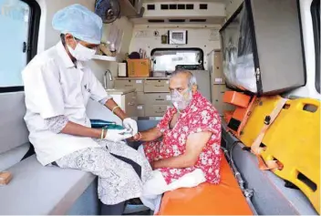  ?? Reuters ?? A paramedic uses an oximeter to check the oxygen level of a patient inside an ambulance while waiting to enter a Covid-19 hospital for treatment, amidst the spread of the coronaviru­s disease in Ahmedabad. —