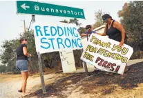  ?? Scott Strazzante / The Chronicle ?? Julie Reaves (left), 11-year-old Aiden Bunas and Naomi Yamamoto of Redding post signs of strength and praise.