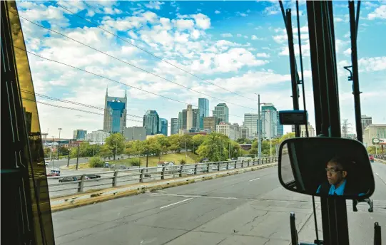  ?? KENNY HOLSTON/THE NEW YORK TIMES PHOTOS ?? The Nashville skyline looms as the Napaway driver, Alfonso, McAllister, steers the bus toward the Tennessee city after an overnight trip from Washington, D.C., Oct. 15, 2022. Startup travel companies are hoping more Americans will embrace the concept of sleeper and luxury coaches, but don’t dare call them buses.