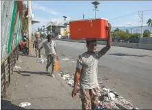  ?? ODELYN JOSEPH / ASSOCIATED PRESS ?? People walk along a street in Port-au-Prince, Haiti, on Wednesday.