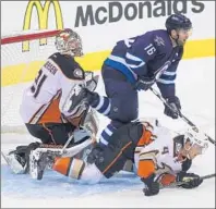  ?? Marianne Helm Getty Images ?? HE PROBABLY didn’t mean to do it, but Cam Fowler trips up Jets’ Andrew Ladd in front of goalie Frederik Andersen.