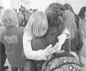  ??  ?? Kim McCreery a seventh-grade English teacher in Tecumseh, Okla., holds her daughter, Keira, 5, as they rally. PHOTOS BY DAVID WALLACE/USA TODAY NETWORK