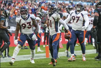  ?? GARY MCCULLOUGH — THE ASSOCIATED PRESS ?? From left, Broncos defensive end Dre’mont Jones (93), safety Justin Simmons (31) and defensive tackle D.J. Jones (97) celebrate an intercepti­on by Simmons against the Jacksonvil­le Jaguars at Wembley Stadium in London on Sunday.