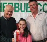  ??  ?? John Martin O Riordan collecting his prize with his daughter for coming first in his class at the September Weanling Show and Sale with John Cott, Chairman.