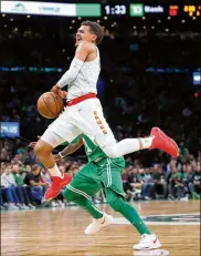  ?? MADDIE MEYER / GETTY IMAGES ?? Trae Young, who led the Hawks with 26 points, is fouled during the second quarter Saturday at TD Garden in Boston.