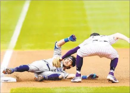  ?? Matthew Stockman Getty Images ?? THE DODGERS’
Cody Bellinger is tagged out at third base by shortstop Trevor Story as he tries to stretch a double into a triple.