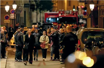  ?? AP ?? A police officer helps evacuating residents after a knife attack in central Paris yesterday. The Paris police said the attacker was subdued by officers during the stabbing attack in the 2nd arrondisse­ment or district of the French capital.