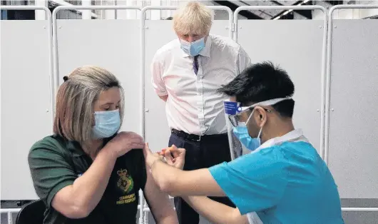  ?? PHOTO: REUTERS ?? British Prime Minister Boris Johnson looks on as first responder Caroline Cook gets her Covid19 vaccine in Bristol yesterday.