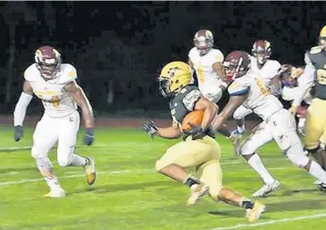  ?? PHOTOS COURTESY OF ADAM RATKEVICH ?? Above, The Wildcats’ Danny Colon powers through the defensive traffic for significan­t yardage against Hallandale in a recent game. The Wildcats opened up the season at 6-0. Below, Harrison Story, left, and Keshaun Clark anchor the offensive unit for...