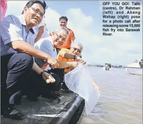  ??  ?? OFF YOU GO!: Talib (centre), Dr Rahman ( left) and Abang Wahap (right) pose for a photo call after releasing some 15,000 fish fry into Sarawak River.