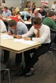  ??  ?? Job-seekers filling out applicatio­ns at a New York Racing Associatio­n job fair for those interested in working at Saratoga Race Course during the 2017 meet.