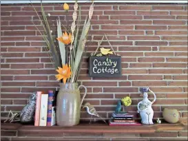  ??  ?? A sign above the fireplace mantle at Jean Bray’s home displays the name “Canary Cottage.”