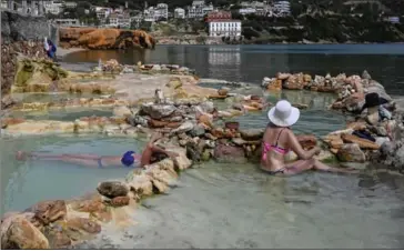  ?? AFP ?? Visitors enjoy a hot springs natural pools on the Greek island of Eubea. Greece is preparing to open borders for local and internatio­nal tourists on May 15.
