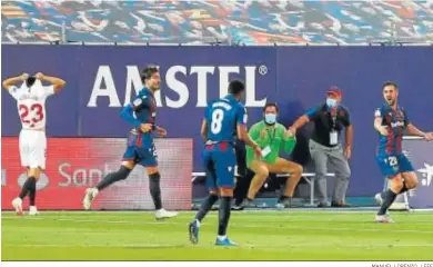  ?? MANUEL LORENZO / EFE ?? Los jugadores del Levante celebran el empate ante la desesperac­ión de Reguilón.