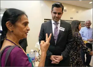  ?? The Associated Press ?? MIDTERM SPENDING: Thara Narasimhan, left, talks to candidate Sri Kulkarni during a July 29 fundraiser in Houston. Narasimhan, who hosts an Hindu radio program in Houston, has already given $1,200 to Kulkarni, a Democrat running against Republican U.S. Rep. Pete Olson.