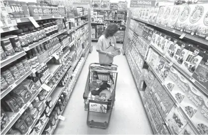  ?? Associated Press file photo ?? ABOVE: In this Dec. 14, 2010, file photo, Alicia Ortiz shops through the cereal aisle as her daughter Aaliyah Garcia catches a short nap in the shopping cart at a Family Dollar store in Waco, Texas.