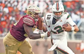  ??  ?? Miami quarterbac­k Malik Rosier runs the ball past Florida State defensive tackle Demarcus Christmas on Oct. 7. MELINA VASTOLA, USA TODAY SPORTS