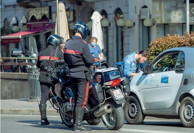  ?? (foto Alberico) ?? Le pattuglie Un equipaggio dei carabinier­i motociclis­ti controlla un ragazzo su un’auto di car sharing nel tratto iniziale di corso Buenos Aires. Oltre 5 mila le verifiche ieri