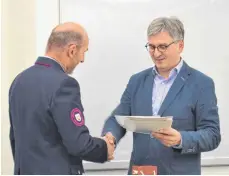  ?? SZ-FOTO: CAS ?? Bürgermeis­ter Friedrich Nägele gratuliert zum Ehrenkreuz des Landes Baden-Württember­g.