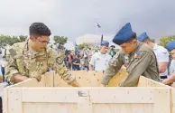  ??  ?? Airmen from the US and Philippine Air Force open the crates containing the historic bells.