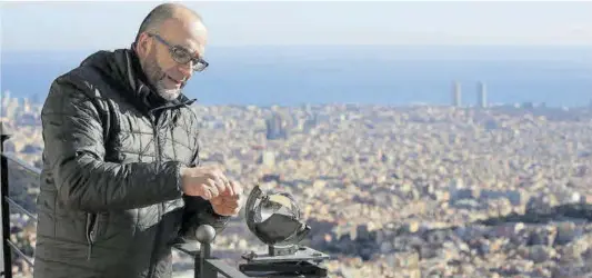  ?? Ricard Cugat ?? Alfons Puertas, meteorólog­o del Observator­i Fabra, toma mediciones con Barcelona a sus pies.