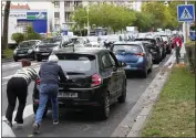  ?? MICHEL EULER — THE ASSOCIATED PRESS ?? People push their car in a line of vehicles waiting to reach a gas station in Nanterre, outside Paris, on Friday.