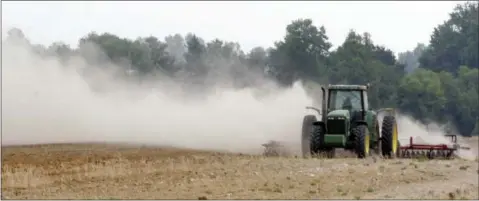  ?? GENE BLYTHE — THE ASSOCIATED PRESS FILE ?? In this file photo, a farm tractor scatters dust as it moves across a field on a farm along state road 82 near Tifton, Ga. Soil is an important natural resource that must be preserved against loss by such forces as wind erosion.