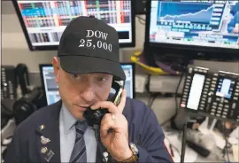  ?? MARK LENNIHAN — ASSOCIATED PRESS ?? Vincent Pepe, a broker with ICAP Corp., sports a “Dow 25,000” hat Thursday at the New York Stock Exchange. The Dow is trading above 25,000for the first time.