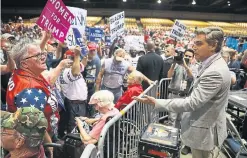  ?? JOE RAEDLE/GETTY IMAGES ?? CNN reporter Jim Acosta “debates” the issues with supporters of U.S. President Donald Trump at a rally in Tampa. Then he signed some autographs.