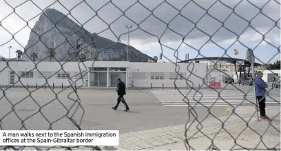  ??  ?? A man walks next to the Spanish immigratio­n offices at the Spain-Gibraltar border