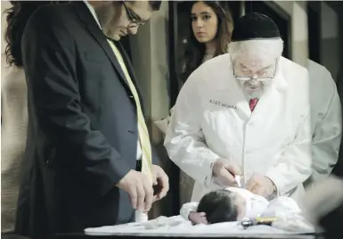  ??  ?? Abraham Romi Cohn, right, examines Yosef Sananas before performing his bris, or ritual circumcisi­on, in New York.