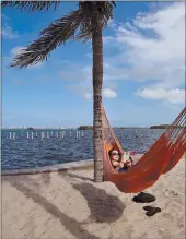  ?? Associated Press ?? Kristiina Nurk, 34, enjoys a good book underneath the blue summer-like skies and weather as she vacations in Miami on May 2. Are you going on vacation this summer? Facebook.com/appealdemo­crat. Twitter.com/appealdemo­crat. Email us: adletters...