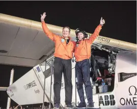  ?? PHOTO: ?? Pilots Andre Borschberg (left) and Bertrand Piccard celebratin­g the landing of their plane at an airport in Abu Dhabi, United Arab Emirates, on Tuesday. The world's first round-the-world flight, to be powered solely by the sun's energy, made history on...