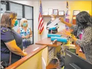  ??  ?? Laura Sanchez, left, Jeani Adams and Carolyn Jones, second right, deliver the petition signatures to City Clerk Sabrina Mercadante, right, at Henderson City Hall.