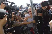  ?? RODRIGO ABD / ASSOCIATED PRESS ?? The media ring an anti-migrant demonstrat­or arguing with a woman at a protest Sunday against Central American migrants in Tijuana, Mexico.