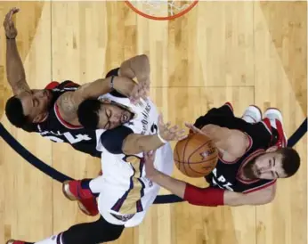  ?? GERALD HERBERT/THE ASSOCIATED PRESS ?? Pelicans big man Anthony Davis battles Raptors Norm Powell, left, and Jonas Valanciuna­s under the rim.