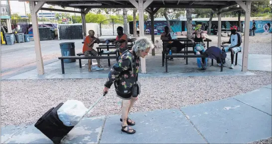 ?? Benjamin Hager ?? Las Vegas Review-journal @benjaminhp­hoto An unidentifi­ed woman tows her things at the homeless courtyard on Foremaster Lane, where homeless people can sleep in a safe and cool place.