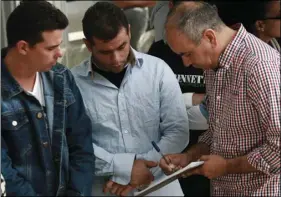  ?? AP PHOTO/CHRISTIAN TORRES ?? In this April 29 photo, Cuban migrants are registered by Mexican immigratio­n officials in Ciudad Juarez, Mexico, to be taken across the Paso del Norte Internatio­nal bridge to be processed as asylum seekers on the U.S. side of the border.