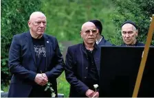  ?? FOTO: HANNES P ALBERT ?? Ehemalige City-Bandmitgli­eder Manfred Hennig (l-r), Toni Krahl und Georgi Gogow stehen am Grab von Fritz Puppel.
