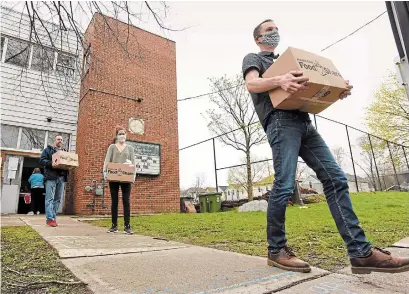  ?? JOHN RENNISON THE HAMILTON SPECTATOR ?? From left, Deryk Lee, Kate MacKenzie and Jamie VanderBerg load boxes to be delivered on behalf of Food Share Hamilton.