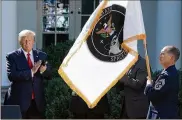  ?? CHIP SOMODEVILL­A / GETTY IMAGES ?? President Donald Trump applauds as the U.S. Space Command flag is revealed Thursday in the White House’s Rose Garden in Washington, D.C.