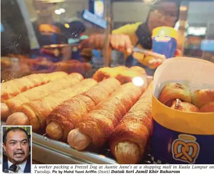  ??  ?? A worker packing a Pretzel Dog at Auntie Anne’s at a shopping mall in Kuala Lumpur on Tuesday. Pic by Mohd Yusni Ariffin (Inset) Datuk Seri Jamil Khir Baharom