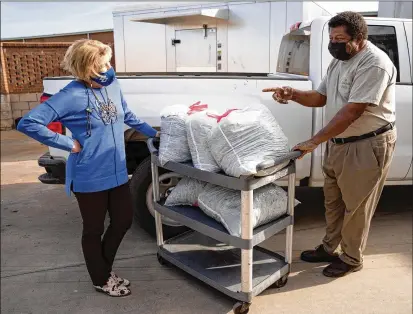  ?? PHOTOS BY SEAN RAYFORD/THE WASHINGTON POST ?? Donna Martin (left) talks with farmer Pete Jackson, from whom she buys heaps of local collard greens that kitchen manager Melinda Mitchell simmers with a little chicken bouillon.