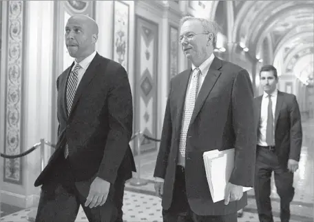  ?? Alex Wong Getty Images ?? U.S. SEN. Cory Booker, left, walks with Eric Schmidt, executive chairman of Google parent firm Alphabet, in Washington in July.