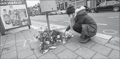  ??  ?? Een passant legt bloemen neer op de plek des onheils in Tilburg. (Foto:ANP)