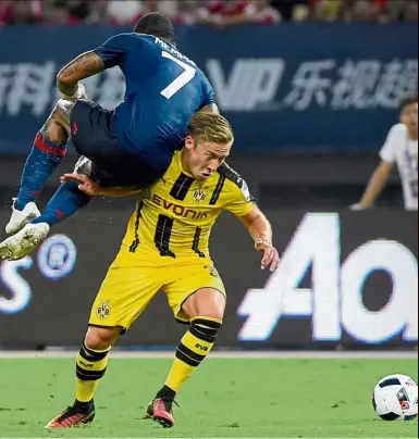  ??  ?? Horror show: Manchester United’s Memphis Depay (left) tussling for the ball with Borussia Dortmund’s Felix Passlack in the Internatio­nal Champions Cup match in Shanghai on Friday. Below: United manager Jose Mourinho reacts after Dortmund scored the...